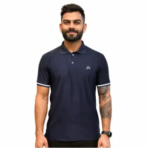 A man with short hair and a beard is wearing a navy blue polo shirt with white trim. He stands confidently against a white background, displaying a calm demeanor.