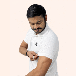 A man adjusts his shirt, wearing an Athlayer white polo, against a plain white background.