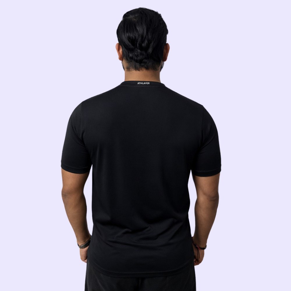 The back view of a man in a black V-neck T-shirt, exuding a casual and confident style.