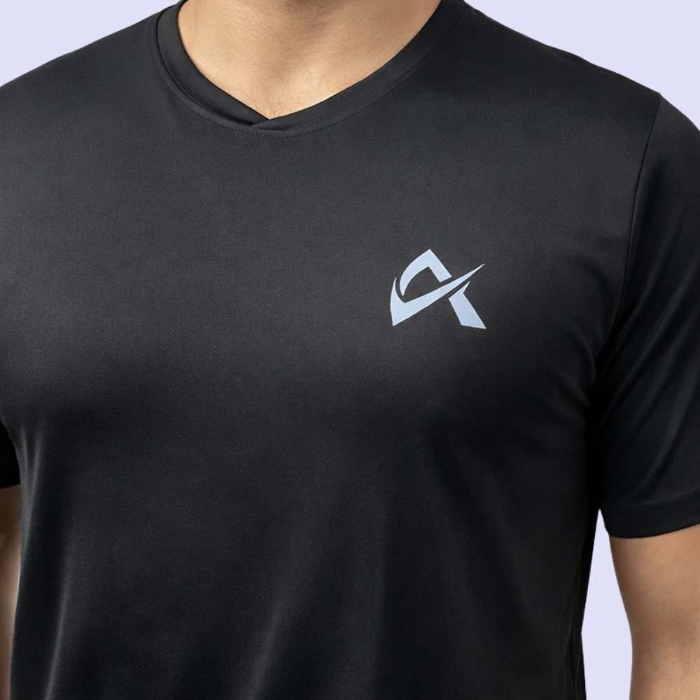 A man confidently wears a black V-neck T-shirt, displaying the logo on the front in a casual, stylish manner.