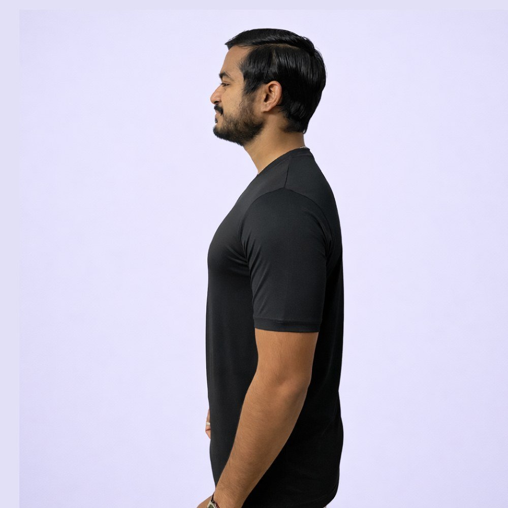 A man in a black V-neck T-shirt stands confidently against a white background, exuding a casual and stylish appearance.