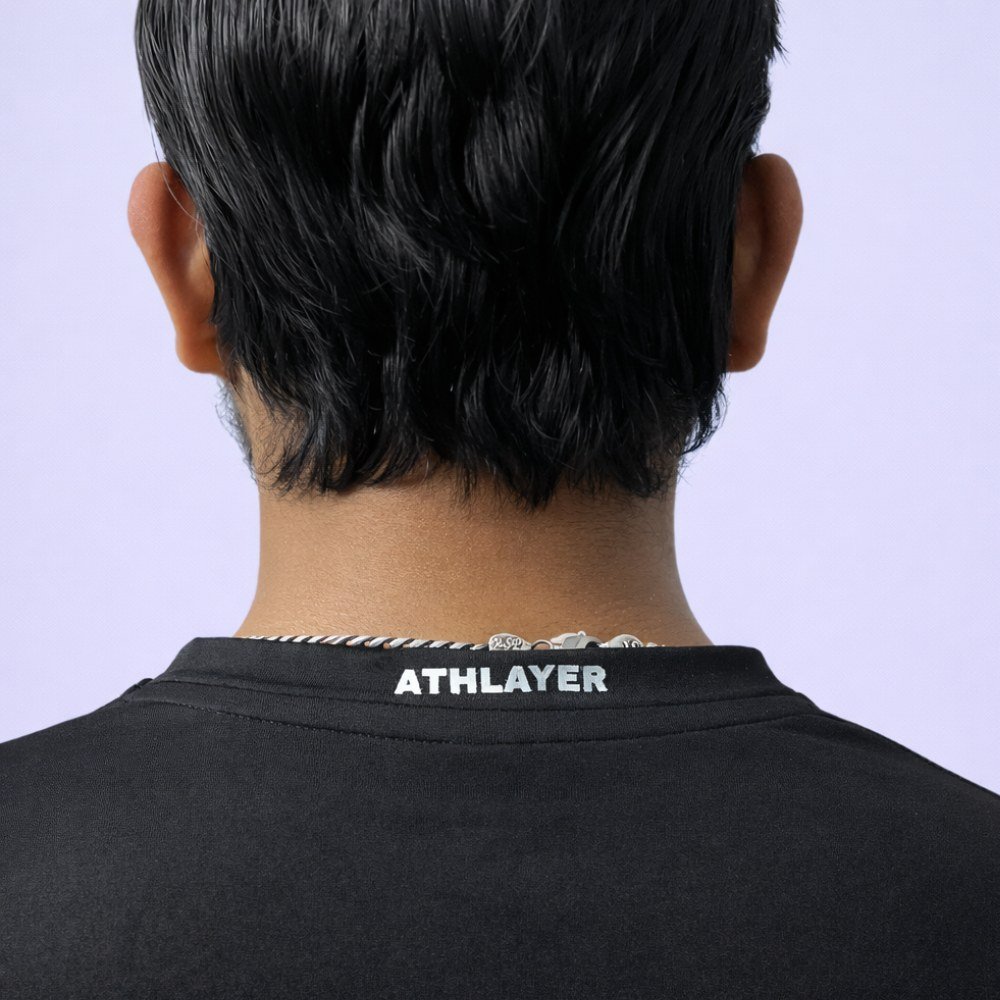 A man confidently wears a black V-neck T-shirt, presenting a casual and stylish appearance.