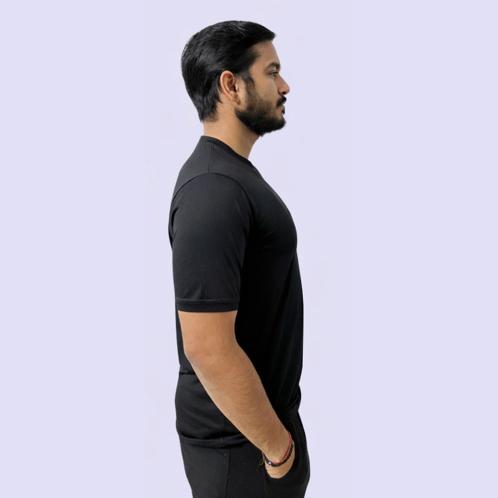 A man in a black V-neck T-shirt stands confidently against a white background, exuding a casual and stylish vibe.