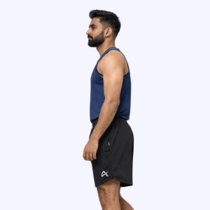 Side pose of a man wearing a blue tank top and black running shorts, exuding a sporty and stylish vibe.