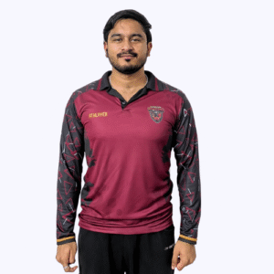 A man in a maroon cricket jersey poses for a photo, smiling confidently at the camera.